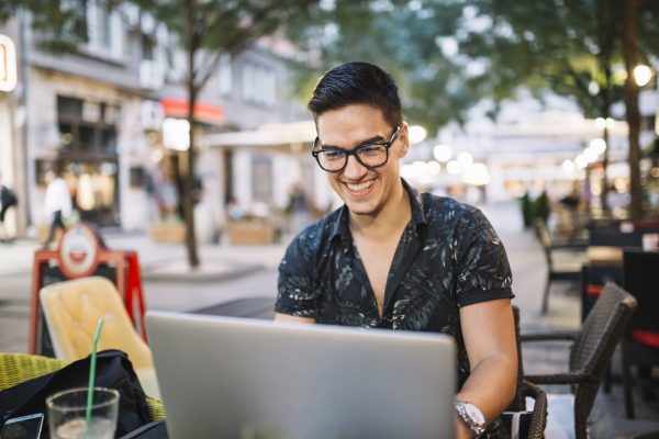 smiling-man-working-laptop-caf